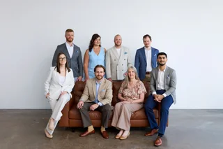 The Noulty Financial team gathered around a leather couch